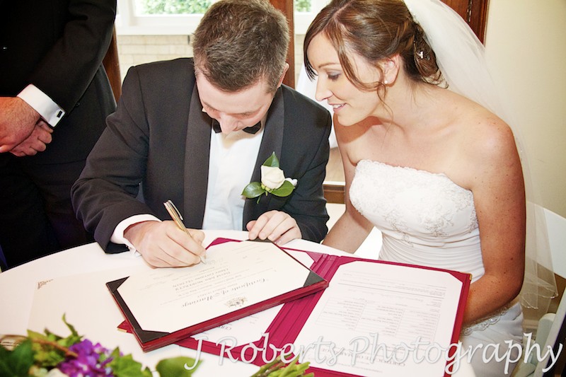 bride and groom signing the wedding certificate - wedding photography sydney